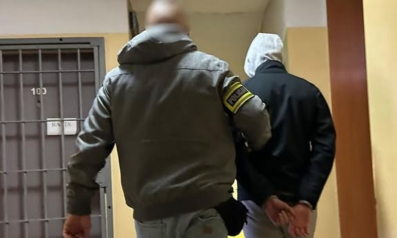 policjant idzie z zatrzymanym