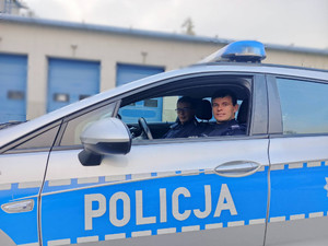 dwóch policjantów siedzi w radiowozie.