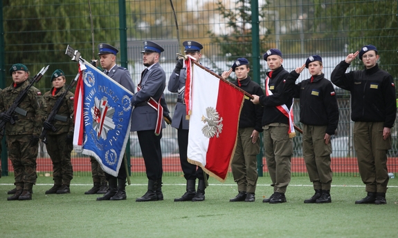 Uczniowie kilku klas mundurowych podczas uroczystości na płycie boiska.