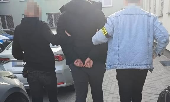 policjanci idą z zatrzymanym