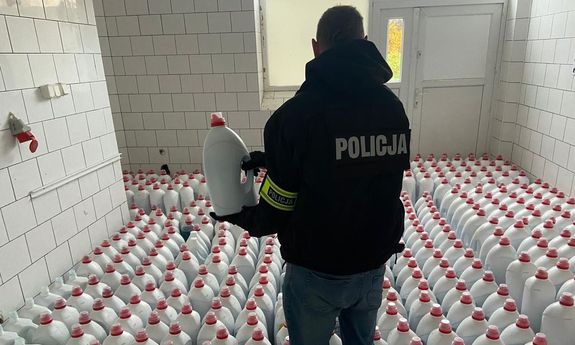 policjant stoi w pomieszczeniu pełnym białych butelek.