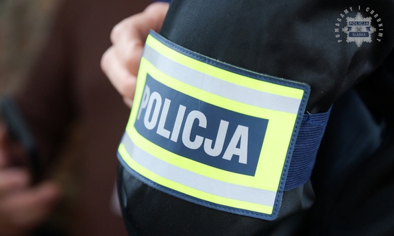 Opaska z napisem Policja na ramieniu funkcjonariusza.