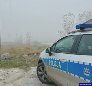 Na zdjęciu oznakowany radiowóz w miejscu poszukiwań zaginionej seniorki.