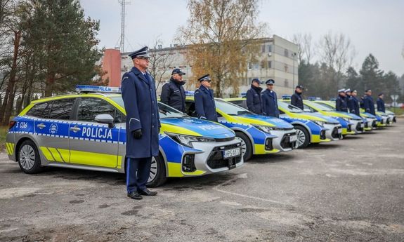 nowe radiowozy, obok policjanci.