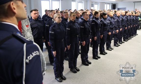 Stojący w dwuszeregu podczas uroczystości nowo przyjęci policjanci.