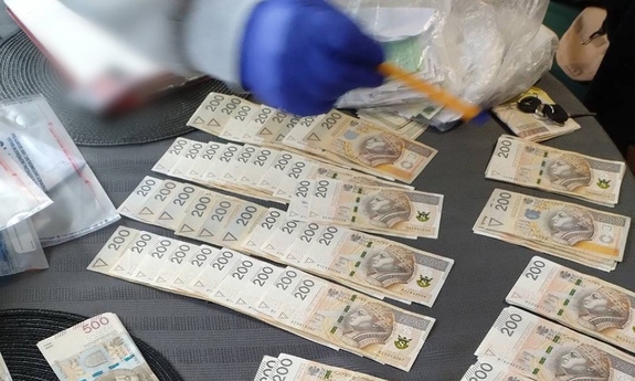 Zabezpieczone przez policjantów banknoty leżą na stole.