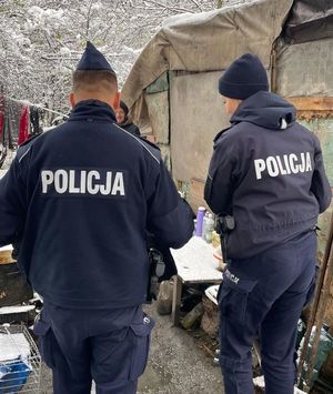 Dwaj policjanci w miejscu przebywania osób bezdomnych.