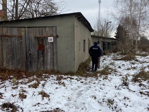 Na zdjęciu umundurowany funkcjonariusz w trakcie obchodu pustostanu.