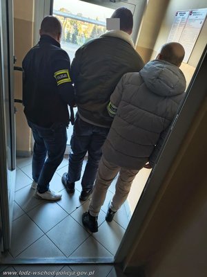 dwóch policjantów stoi z zatrzymanym.