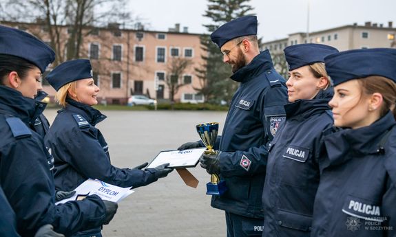 policjantka daje dyplom policjantowi.