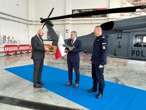 Komendant Główny Policji i dwaj inni mężczyźni stoją obok Black Hawka.