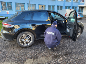 policjant obok porsche.