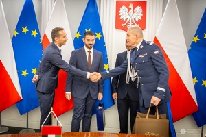 I zastępca komendanta głównego Policji podczas spotkania z przedstawicielami Policji z Dubaju. W tle flagi Polski i Unii Europejskiej.