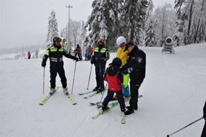 Policjanci z narciarzami na stoku.