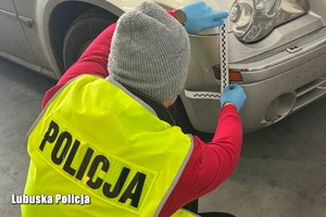 Na zdjęciu policjant prowadzi oględziny pojazdu.