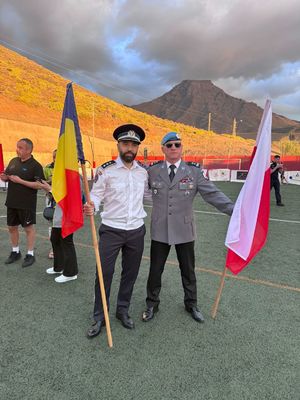 Na zdjęciu umundurowany policjant trzyma w ręku flagę Polski, obok niego stoi mężczyzna z flagą Rumunii w ręku.