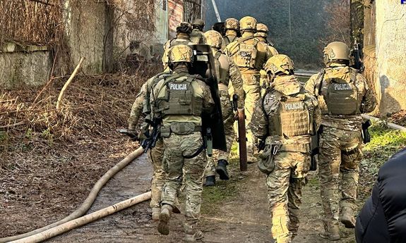 policjanci idą do budynku.