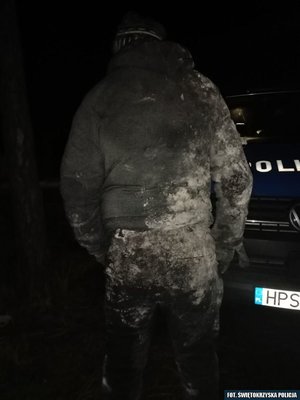 Odwrócony tyłem mężczyzna uratowany przez policjantów.