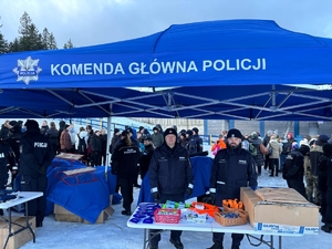 Policjanci przy stoisku profilaktycznym promują bezpieczeństwo.