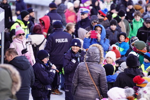 Na zdjęciu umundurowani policjanci stoją przy stoisku policyjnym.