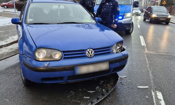 Zatrzymany volkswagen, radiowóz i umundurowani policjanci stojący obok.