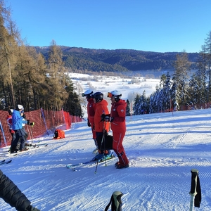 Trójka instruktorów na stoku na tle zimowego pejzażu górskiego.