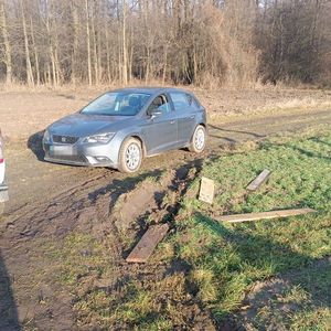 Samochód stoi poza drogą publiczną na polu.