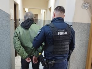 Zdjęcie przedstawia umundurowanego policjanta wraz z zatrzymanym mężczyzną.