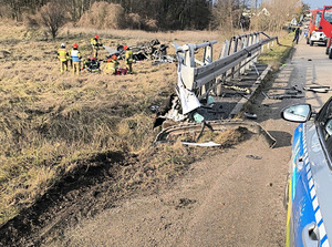 Strażacy pracują na miejscu wypadku przy rozbitym samochodzie.