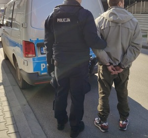 policjanci idą z zatrzymanym.