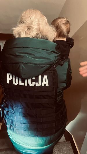 Policjantka z dzieckiem na rękach.