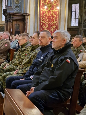 Komendant Główny Policji wśród innych uczestników uroczystości w kościele.