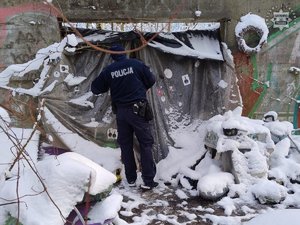 zima, śnieg leży na ziemi. policjant sprawdza miejsce w pustostanie.