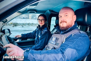 Policjant i policjantka w radiowozie.