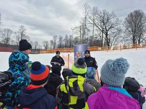 Dwóch policjantów podczas rozmowy z grupą dzieci.