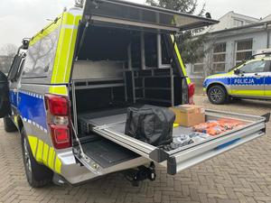 Zdjęcie przedstawia przestrzeń ładunkową radiowozu oznakowanego typu pick-up Isuzu D-MAX