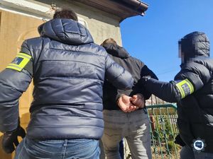 dwóch policjantów z zatrzymanym.
