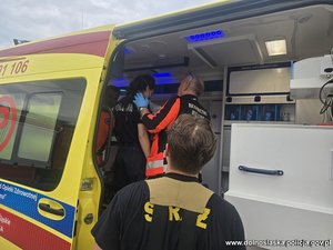 Lekarze badają w karetce policjantkę.