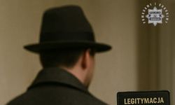 Na zdjęciu widoczny z tyłu mężczyzna w kapeluszu. W prawym dolnym rogu częściowo widoczna Legitymacja detektywistyczna.