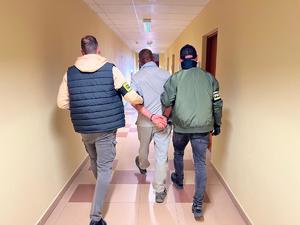 Dwaj policjanci z zatrzymanym.
