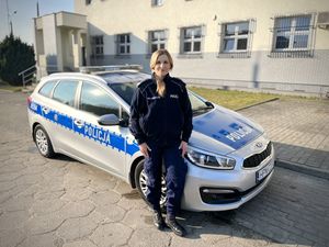 policjantka stoi przed radiowozem.