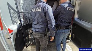 Policjanci prowadzą zatrzymanego.