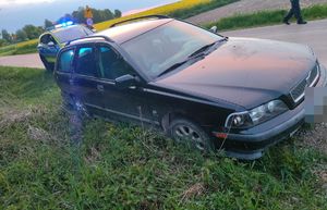 Samochód z poboczu, za nim stoi radiowóz.