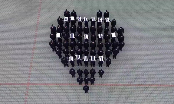 Grupa policjantów stoi na placu tworząc kształt serca.