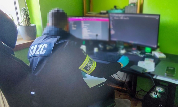Funkcjonariusz CBXC siedzi przy ekranie komputera.