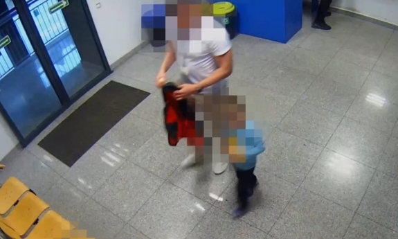 Mężczyzna z dzieckiem w komisariacie - stopklatka z monitoringu.