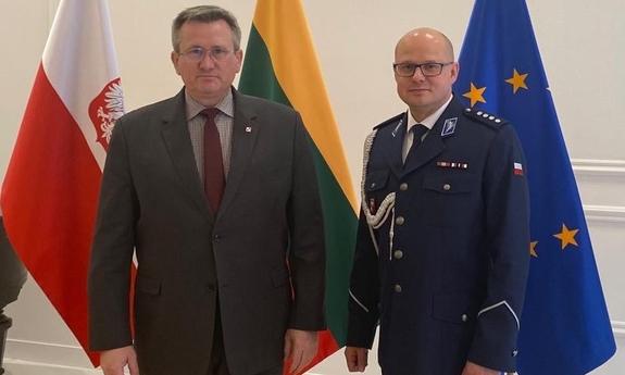 Mężczyzna w garniturze i umundurowany policjant.