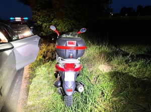 Motocykl stoi obok radiowozu.
