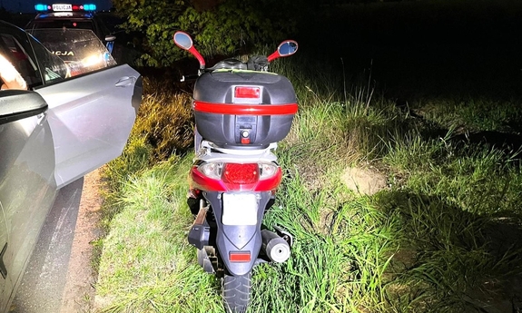 Motocykl stoi obok radiowozu.