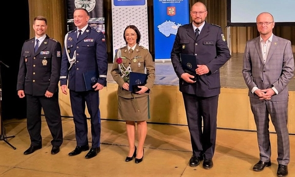 Wyróżnione medalami osoby stoją w szeregu.
